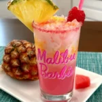 Colorful Malibu Barbie drink served in a tropical setting with beach accessories