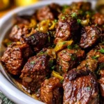 Delicious Mississippi Steak Bites served on a plate with herbs.